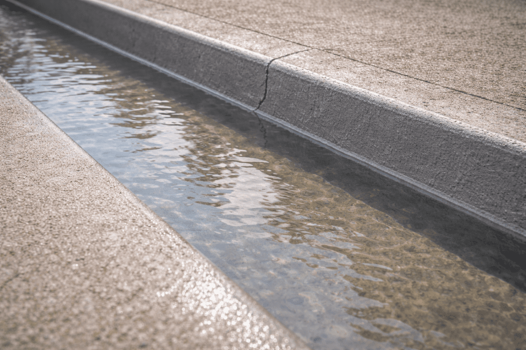 Hasil akhir perbaikan talang air beton yang sedang menjalani uji rendam (ponding test) untuk memastikan tidak ada kebocoran.